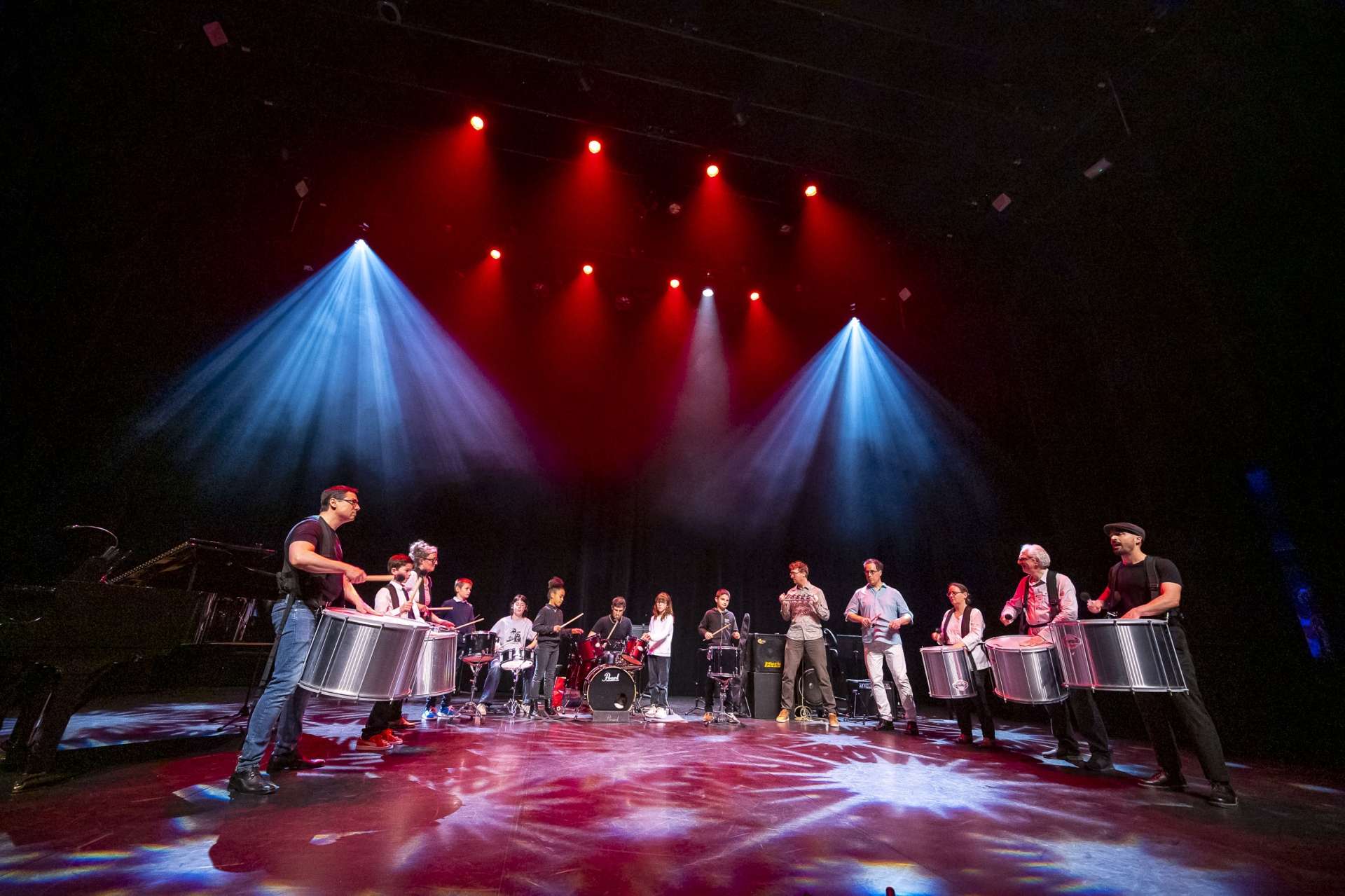 groupe de jeunes musiciens sur scène avec lumières rouge