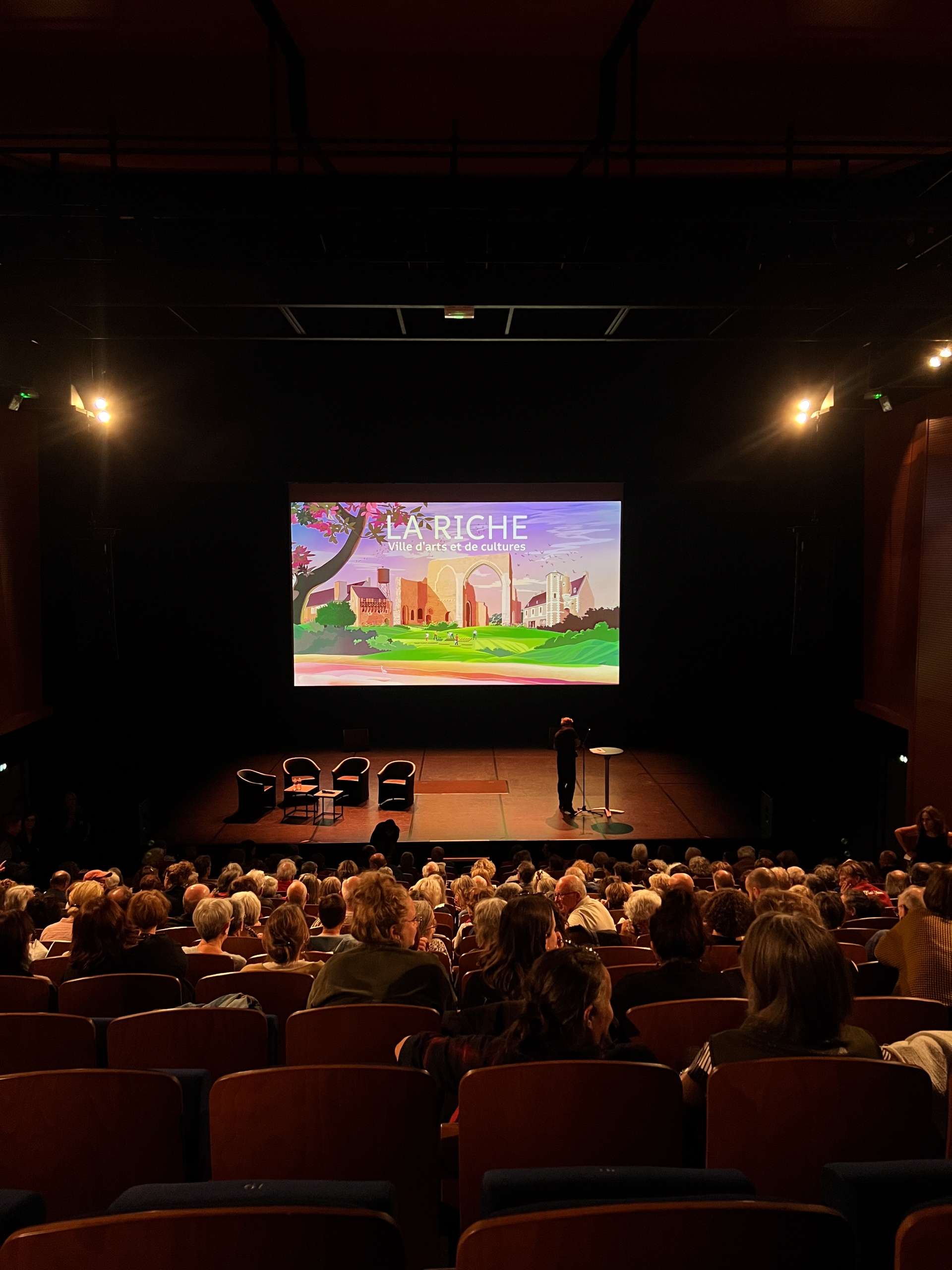 salle de spectacle dans le noir avec projection